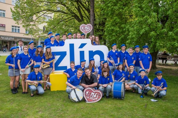 Hudebníci dechového orchestru u cedule Zlín
